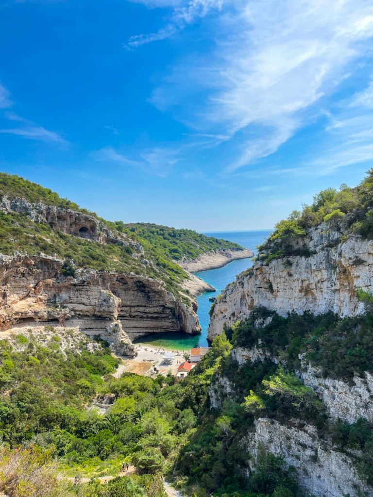 A cove on the island of Vis with clear blue water between steep rocky slopes